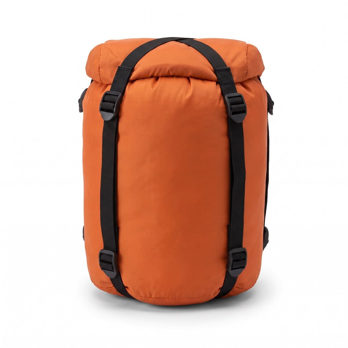 An orange roll-top compression sack with four black straps over the top cap, packed and cinched down