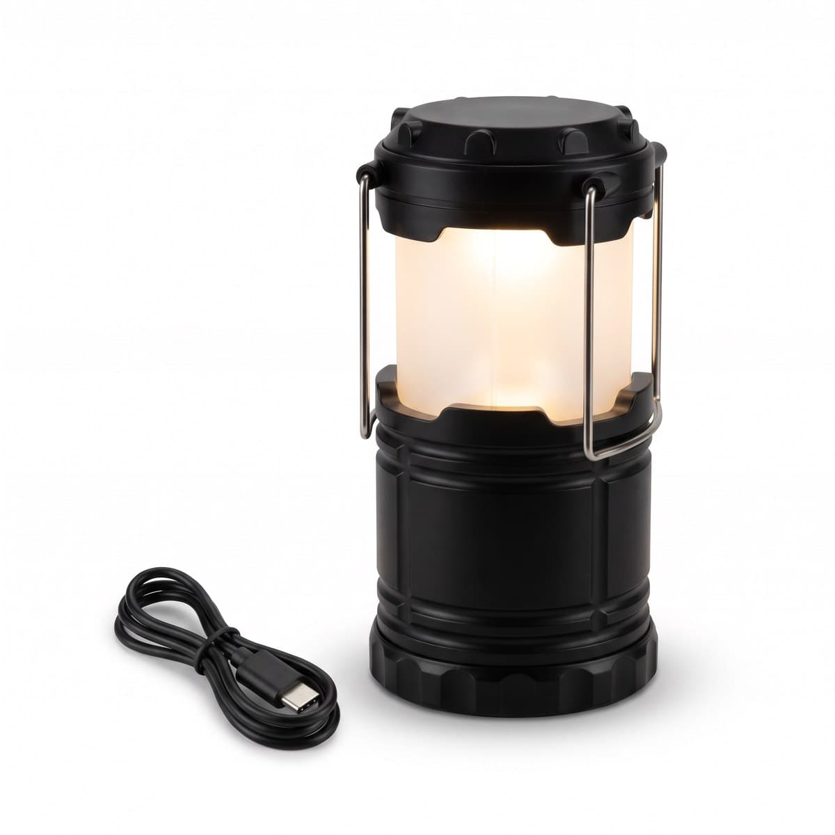 A black collapsible camp lantern pulled up and lit, with its frosted shade glowing and a USB-C cable beside it